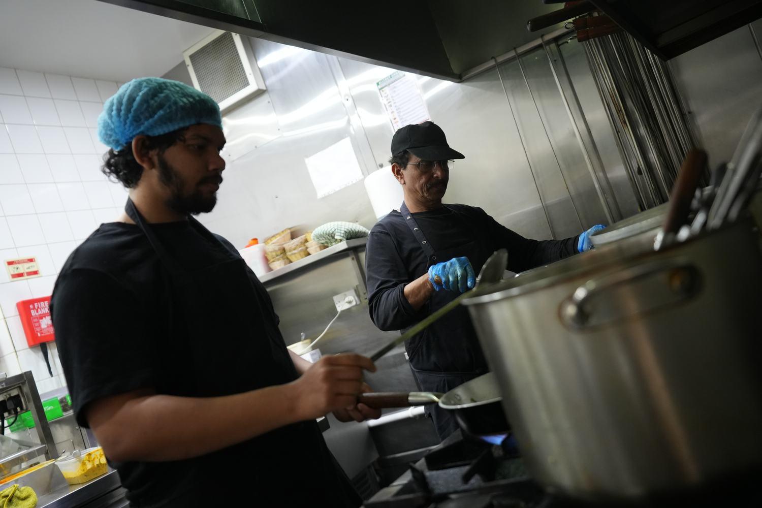 Chefs at work over the curry station pots